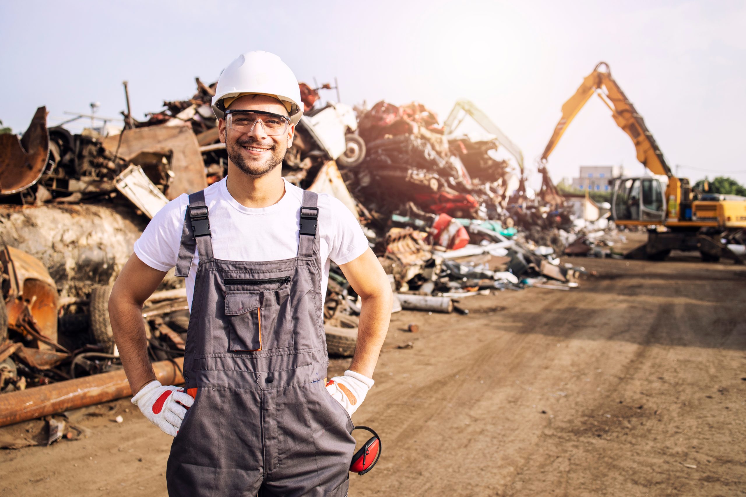 Worker standing in scrap metal yard